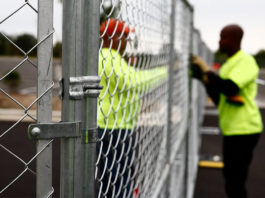 two people putting up a chain-link fence